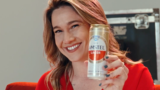 Mulher segurando uma lata de Amstel